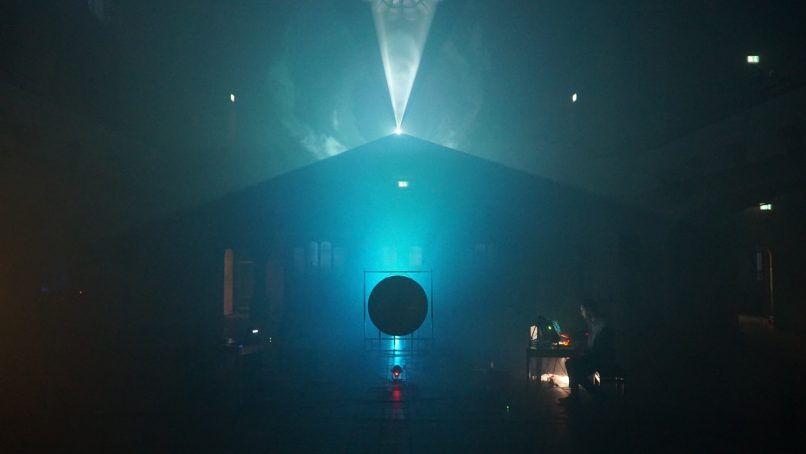 Light beams from projector in fog dark circle silhouette
