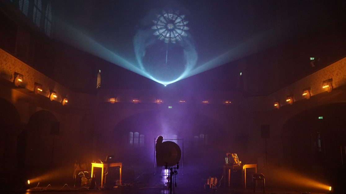 purple and yellow light in a church with projection in fog