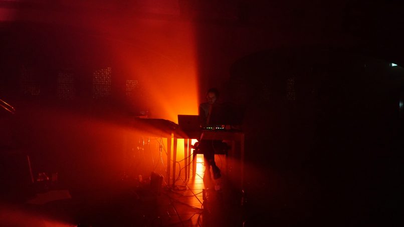 Electronic musician Julius Holtz silhouette in red light beams