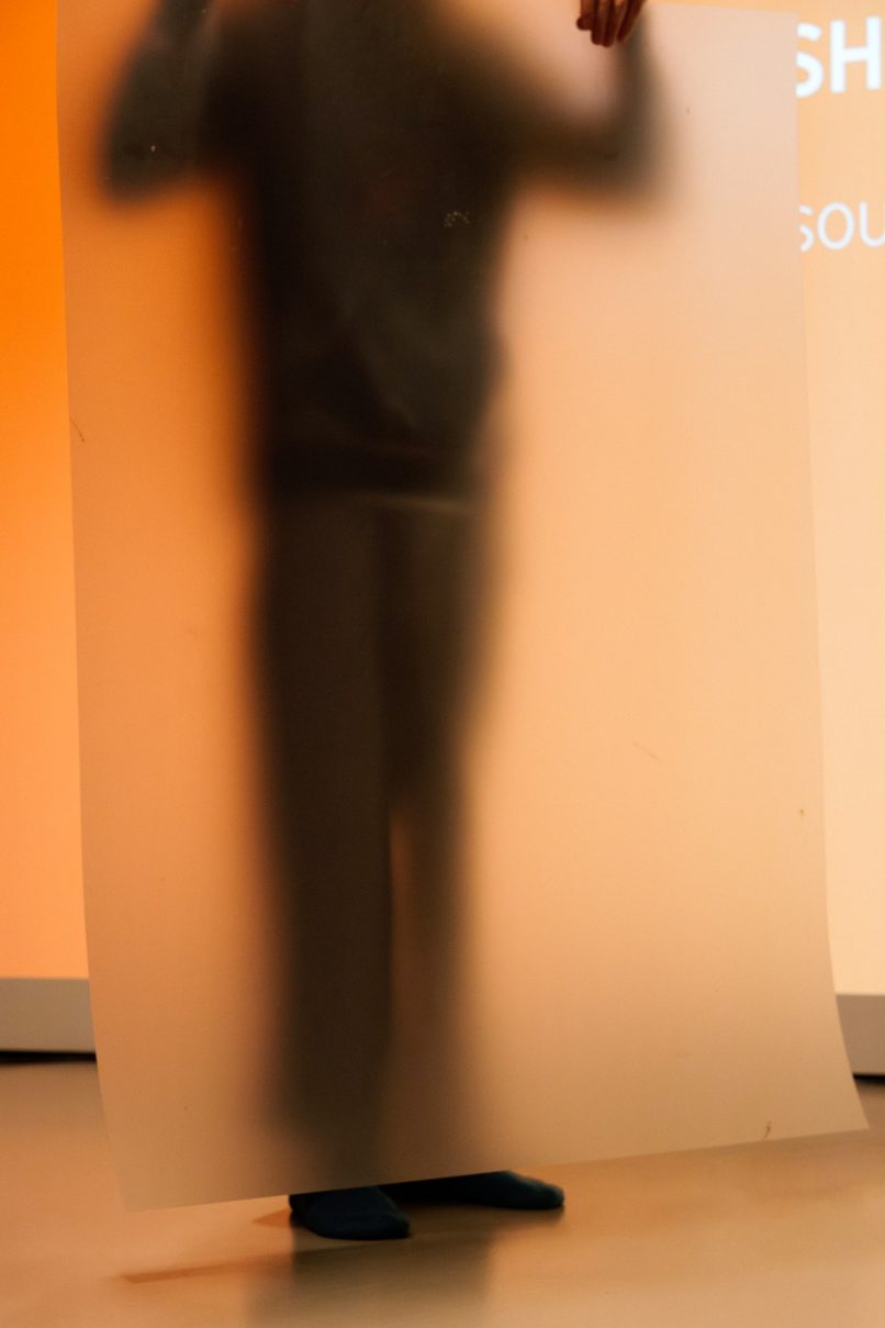 a body, blurred, behind a sheet of plastic