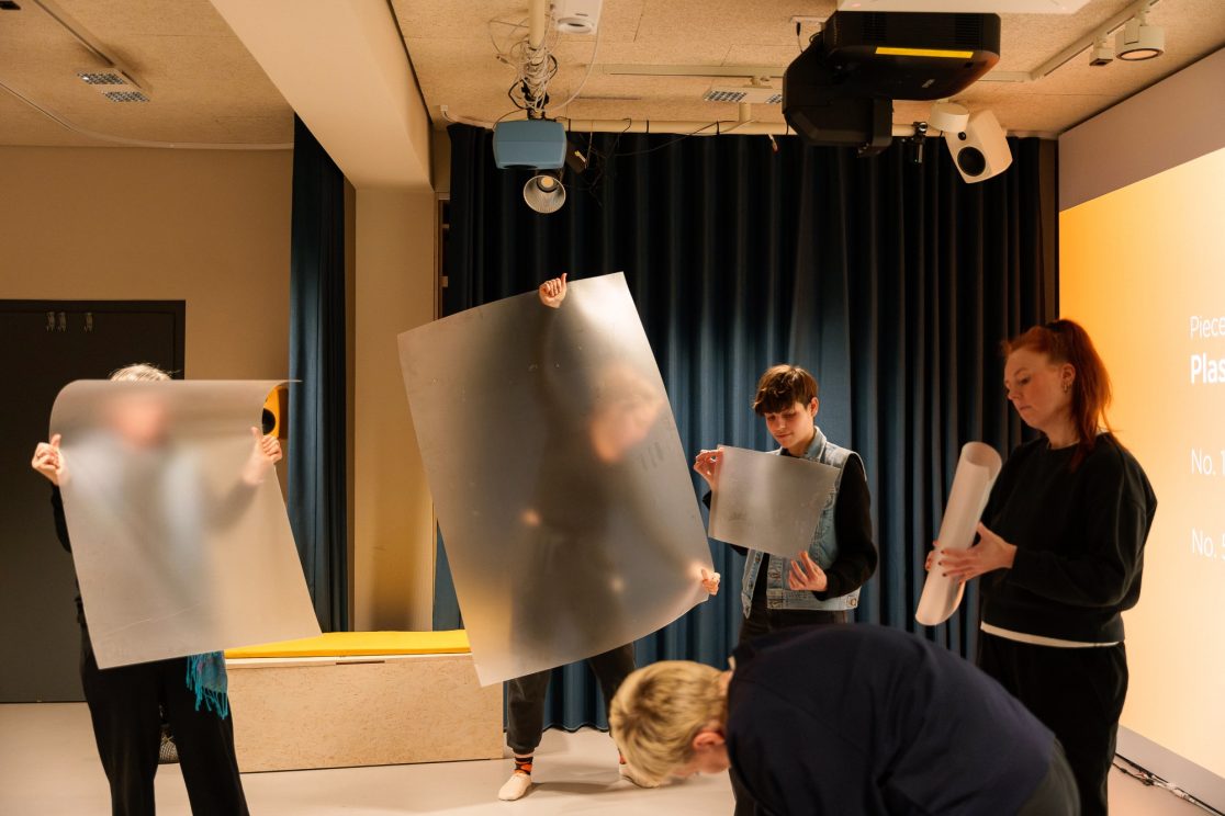 five people interacting in different ways with sheets of plastic